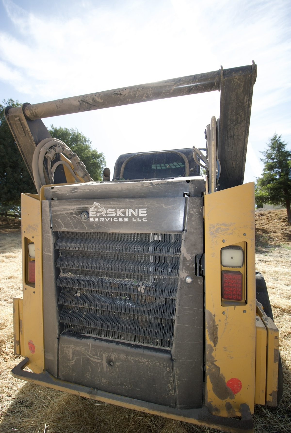Erskine Services LLC branded skid steer loader on a job site